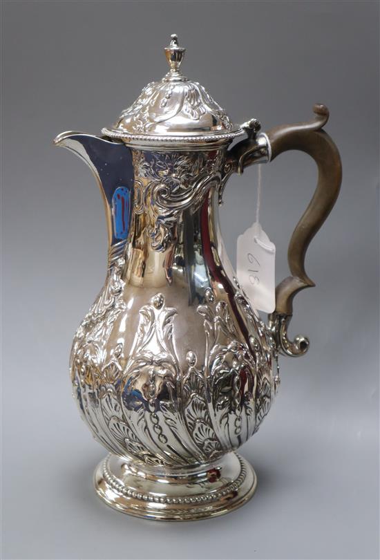 A George III silver hot water pot with later embossed decoration, Charles Wright, London, 1776, gross 25.5 oz.